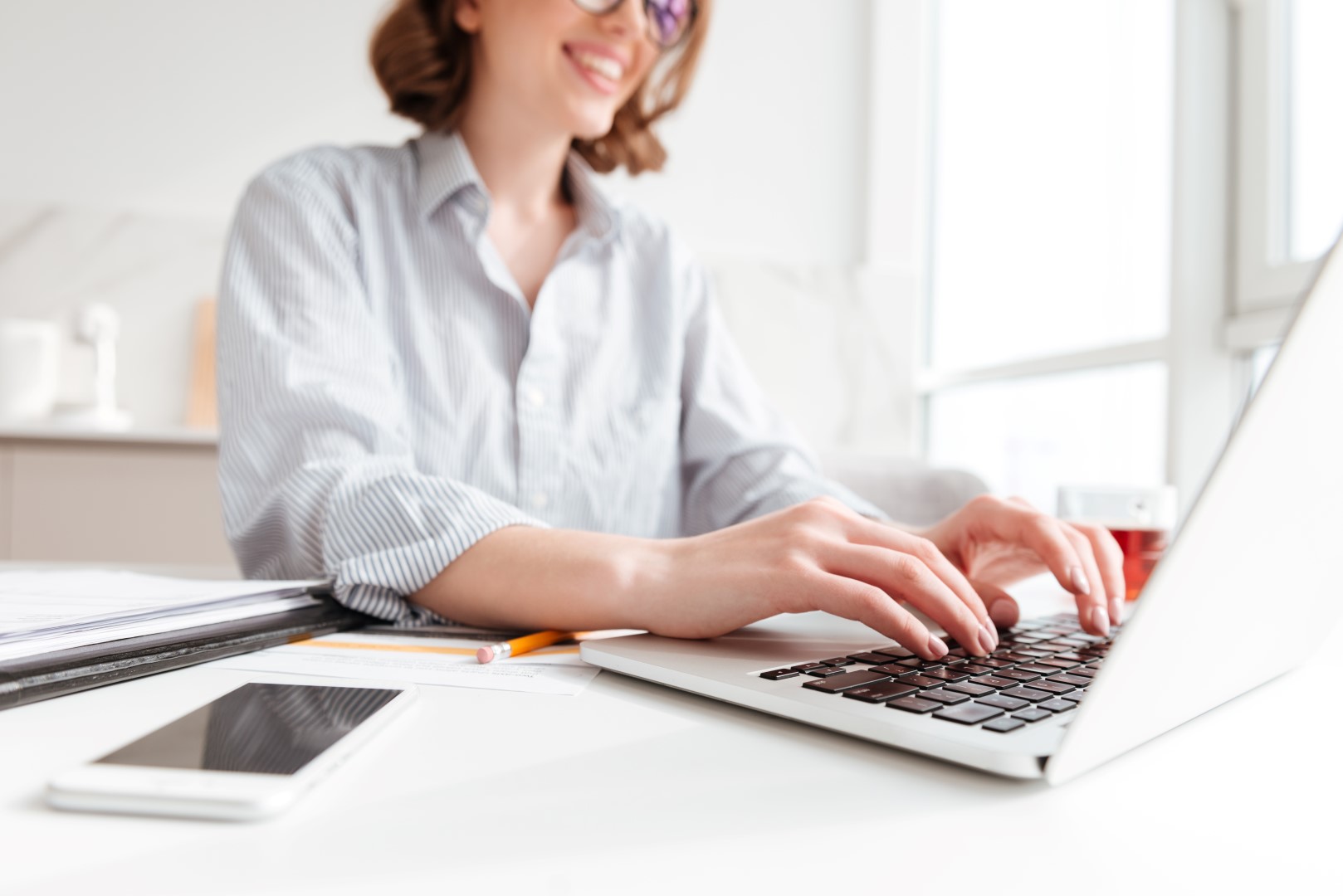 Cropped photo of pretty brunette woman typing email on laptop co