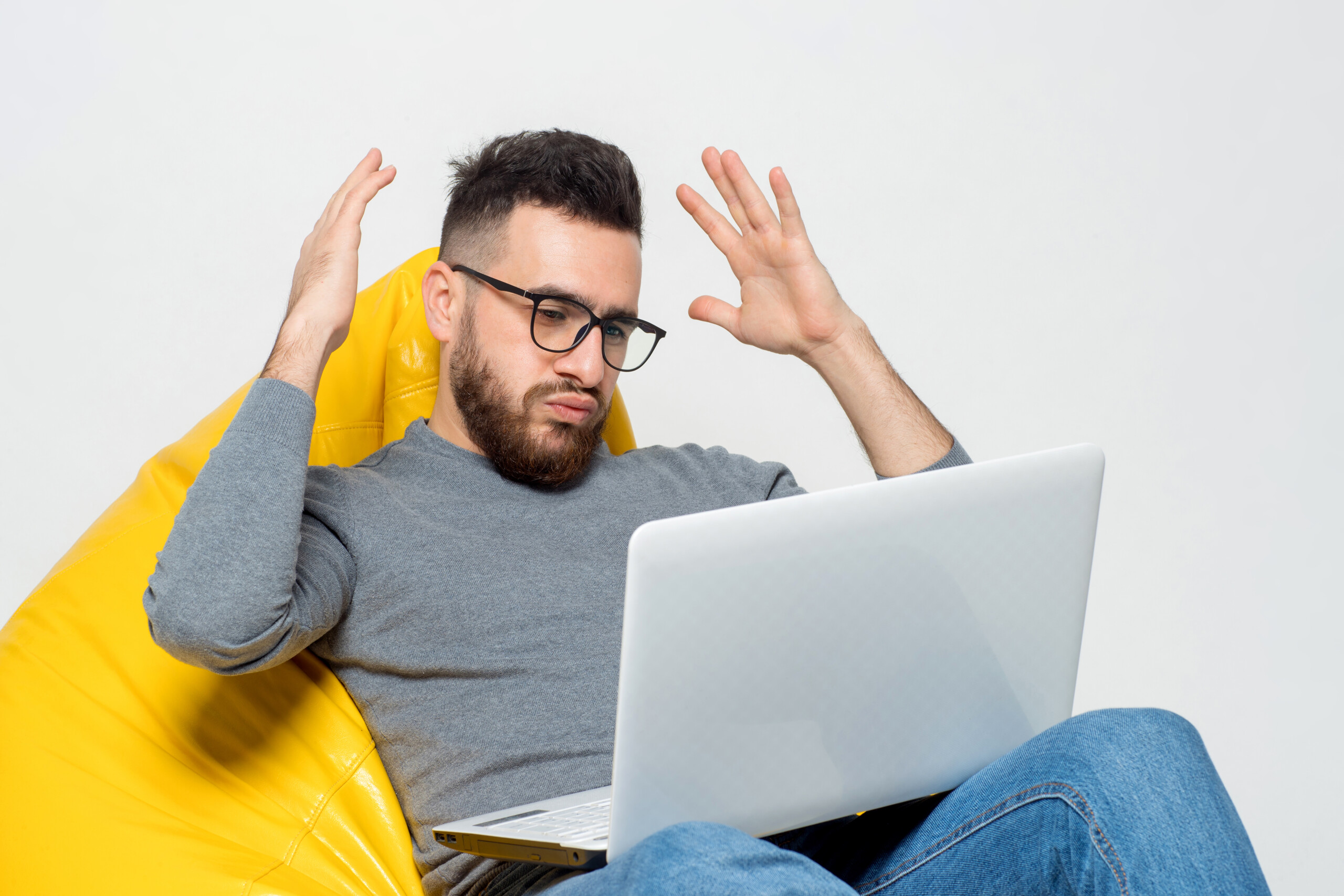guy suprised while sitting yellow pouf chair
